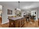 Open kitchen with central island, wood cabinets, and hardwood flooring at 609 Redford Place Dr, Rolesville, NC 27571