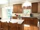 Beautiful kitchen with wooden cabinets, stainless steel appliances, a center island, and a window over the sink at 609 Redford Place Dr, Rolesville, NC 27571