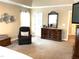 Well-lit main bedroom includes a tray ceiling, plush carpet, and a decorative wall mirror over a dresser at 609 Redford Place Dr, Rolesville, NC 27571