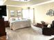 Spacious main bedroom with tray ceiling, carpet floors, natural lighting, and elegant decor at 609 Redford Place Dr, Rolesville, NC 27571