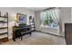 Cozy front room with a piano, large window with sheer curtains, and neutral tones, creating a peaceful and inviting space at 609 Redford Place Dr, Rolesville, NC 27571