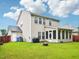 Spacious backyard featuring a fire pit, lush green grass, and a sunroom at 611 Ashbrittle Dr, Rolesville, NC 27571