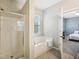 Bathroom featuring a glass-enclosed shower and soaking tub near the window and bedroom at 611 Ashbrittle Dr, Rolesville, NC 27571