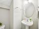 Cozy half-bathroom featuring a pedestal sink, decorative mirror, and neutral color palette at 611 Ashbrittle Dr, Rolesville, NC 27571