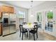 Bright breakfast nook with stainless steel refrigerator, round table, and access to outdoor porch at 611 Ashbrittle Dr, Rolesville, NC 27571