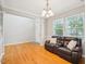 Bright living room with hardwood floors, a leather sofa, and plenty of natural light through the windows at 611 Ashbrittle Dr, Rolesville, NC 27571