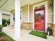Inviting front porch featuring rocking chairs, stone accents, and a red front door with a wreath at 611 Ashbrittle Dr, Rolesville, NC 27571