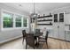Bright dining area with wainscoting, custom cabinets, decorative shelves, and wood flooring at 623 Cabin Crk, Pittsboro, NC 27312
