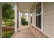 Charming covered front porch with brick accents and black metal railing, offering a welcoming outdoor space at 623 Cabin Crk, Pittsboro, NC 27312