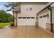 Attached three-car garage with white doors and brick accents at 623 Cabin Crk, Pittsboro, NC 27312