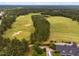 Aerial view showcases a golf course near community residences, with a blend of lush green fairways and wooded landscapes at 623 Cabin Crk, Pittsboro, NC 27312