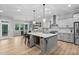 Modern kitchen with a large island, quartz countertops, stainless steel appliances, and pendant lighting at 623 Cabin Crk, Pittsboro, NC 27312