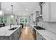 Well-lit kitchen featuring quartz countertops, stainless steel appliances, and an adjacent dining area with ample natural light at 623 Cabin Crk, Pittsboro, NC 27312