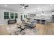 Bright living room with large windows, ceiling fan, and open layout connecting to the kitchen, creating a spacious feel at 623 Cabin Crk, Pittsboro, NC 27312