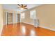 Bedroom featuring wood-look floors, neutral paint, windows, ceiling fan, and closets at 6423 New Market Way, Raleigh, NC 27615