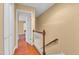 Hallway showcasing wood floors, stairs, a white door, and neutral paint at 6423 New Market Way, Raleigh, NC 27615