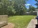 Spacious backyard, bordered by trees, with access to a wooden deck and exterior building at 708 Old Barn Ave, Durham, NC 27704