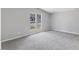 Spacious bedroom with neutral gray walls, plush gray carpet, and large windows at 714 Harriett St, Henderson, NC 27536