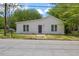 Charming one-story home with white siding, a dark front door, and a well-manicured front lawn at 714 Harriett St, Henderson, NC 27536