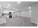 Open-concept kitchen and living space with stainless appliances, white cabinets, and modern vinyl flooring at 714 Harriett St, Henderson, NC 27536