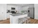 Modern kitchen features an island with seating, stainless steel appliances, and granite countertops at 716 Blazer Bnd, Wendell, NC 27591