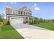 Charming two-story home with a large driveway and an attached two-car garage at 72 Merle Way, Wendell, NC 27591