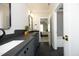Modern bathroom with dark countertops, sleek fixtures, and a view into an adjacent bedroom at 7736 Roberts Rd, Apex, NC 27523