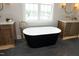 Luxurious bathroom with a freestanding tub, stone floors, and elegant vanity with gold fixtures at 7736 Roberts Rd, Apex, NC 27523