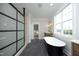 Modern bathroom featuring a black freestanding tub, stone floors, and contemporary fixtures at 7736 Roberts Rd, Apex, NC 27523