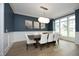 Elegant dining room with a modern chandelier, dark blue walls, and beautiful hardwood floors at 7736 Roberts Rd, Apex, NC 27523