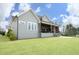 Charming gray two-story home with covered patio, outdoor kitchen, and manicured lawn at 7736 Roberts Rd, Apex, NC 27523