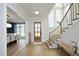 Beautiful foyer featuring light hardwood floors, elegant staircase, and plenty of natural light at 7736 Roberts Rd, Apex, NC 27523
