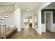 Inviting foyer with herringbone wood floors, a staircase, and a glimpse into the living spaces at 7736 Roberts Rd, Apex, NC 27523