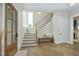 Bright foyer with herringbone wood floors, a wooden front door, and staircase with bench seating at 7736 Roberts Rd, Apex, NC 27523