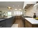 Kitchen with island, stone backsplash, and bi-fold window opening to the outdoor entertaining area at 7736 Roberts Rd, Apex, NC 27523