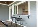 Outdoor pass-through window to kitchen, with stone accent wall, bar seating, and light gray exterior at 7736 Roberts Rd, Apex, NC 27523
