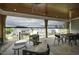 Relaxing covered patio with stone floors, wood ceiling, outdoor furniture, and backyard view at 7736 Roberts Rd, Apex, NC 27523