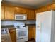 Bright kitchen featuring wooden cabinets, white appliances, and ample counter space at 78 Ariel Street, Lillington, NC 27546