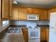 Bright kitchen featuring wooden cabinets, white appliances, and ample counter space at 78 Ariel Street, Lillington, NC 27546
