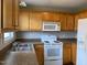 Bright kitchen featuring wooden cabinets, white appliances, and ample counter space at 78 Ariel Street, Lillington, NC 27546