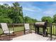 Backyard deck with a grill and two chairs, surrounded by trees at 8204 Charlbert Ct, Apex, NC 27539