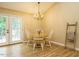 Cozy dining area with wood floors, a round table, chandelier, and doors leading to a patio at 8204 Charlbert Ct, Apex, NC 27539