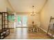 Bright dining area with wood floors, a round table, a chandelier, and access to the kitchen at 8204 Charlbert Ct, Apex, NC 27539