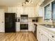 Well-lit kitchen features stainless steel appliances, white cabinets, and modern light fixtures at 8204 Charlbert Ct, Apex, NC 27539