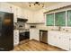 Well-lit kitchen features stainless steel appliances, white cabinets, and modern light fixtures at 8204 Charlbert Ct, Apex, NC 27539