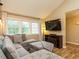 Bright living room with a sectional sofa, hardwood floors, large windows, and a television at 8204 Charlbert Ct, Apex, NC 27539