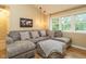 Comfortable living room featuring a large sectional sofa, natural light, and hardwood floors at 8204 Charlbert Ct, Apex, NC 27539