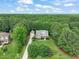 Beautiful aerial view of the home nestled among a dense forest, with a well-manicured lawn and long driveway at 85 Pebble Creek Dr, Franklinton, NC 27525