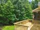 View of an outdoor, wooden back deck and screened-in porch surrounded by mature trees at 85 Pebble Creek Dr, Franklinton, NC 27525