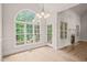 Sun-drenched breakfast nook featuring arched windows, hardwood floors, and elegant lighting fixture, providing serene dining at 85 Pebble Creek Dr, Franklinton, NC 27525
